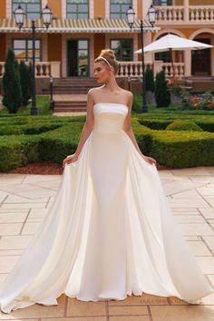 a woman in a white dress standing outside