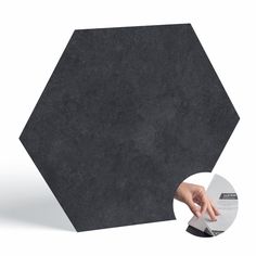 a black hexagonal object with a hand reaching for it