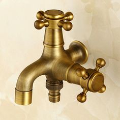 a gold faucet on a white wall