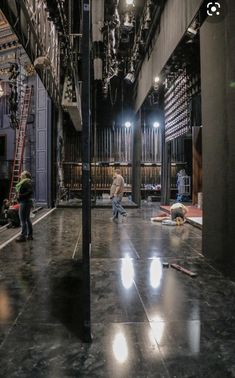 two people are standing in the middle of a large room with many lights on it