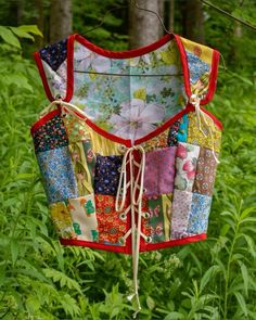 a colorful patchwork top hanging from a tree