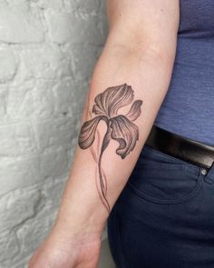 a woman's arm with a flower tattoo on the left side of her arm