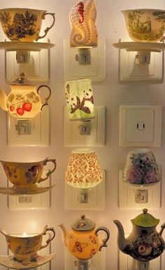 there are many cups and teapots on the wall in front of each other