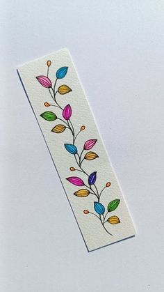 a white bookmark with colorful leaves on it