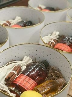 four white buckets filled with different types of condiments and fruit in them