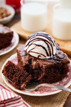 a piece of chocolate cake with ice cream on top is sitting on a red and white plate