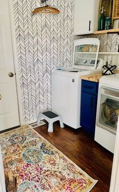 a kitchen area with a rug, stove and washer