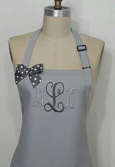 a gray apron with polka dots and a monogrammed bow