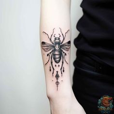 a woman's arm with a bee tattoo on the left side of her arm