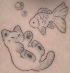 a cat and fish are drawn on the back of a woman's stomach,