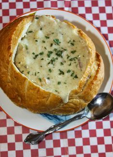 a white plate topped with bread covered in gravy on top of a checkered table