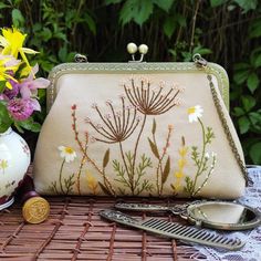 a purse sitting on top of a table next to flowers