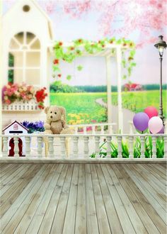 there is a teddy bear sitting on the porch with flowers and balloons in front of it