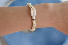 cowrie shell beaded bracelet made with elastic stretchy cord, its a great bracelet to wear for the beach. White Adjustable Stretch Bracelet With Beachy Style, Adjustable White Stretch Bracelet With Beachy Style, White Adjustable Beachy Stretch Bracelet, White Shell-shaped Beaded Bracelets For Vacation, White Strand Stretch Bracelet For The Beach, Beachy White Stretch Bracelet For Vacation, Handmade White Stretch Strand Bracelet, White Cowrie Shell Bracelets For Beach, Adjustable White Stretch Bracelet For Beach Season