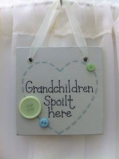 there is a sign that says grandchilden spolit here with buttons on it