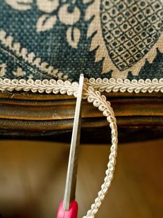 a pair of scissors is being used to trim a piece of fabric