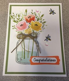 a handmade congratulations card with flowers in a mason jar