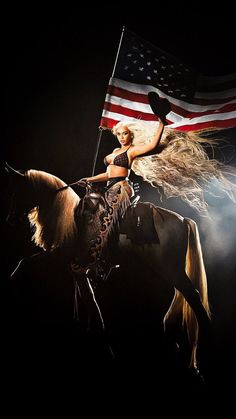 a woman riding on the back of a horse with an american flag in the background