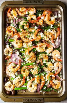 a tray filled with shrimp and vegetables on top of a table