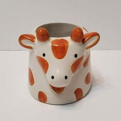 an orange and white ceramic cow head vase