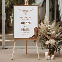 a welcome sign with boots and flowers in front of the entrance to a wedding venue