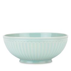 a green bowl sitting on top of a white table