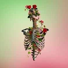 a skeleton with flowers on its back hanging from it's side in the air