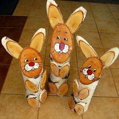 three stuffed animals sitting on top of a tile floor next to each other in the shape of bunnies