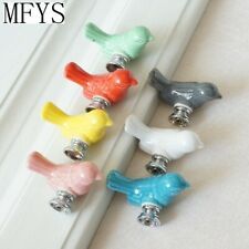 six different colored bird shaped knobs on the side of a white door with metal handles