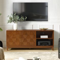 a living room scene with focus on the entertainment center and large screen tv above it