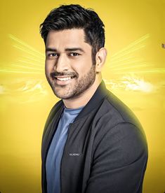 a man with dark hair and beard wearing a black jacket smiles at the camera while standing in front of a yellow background