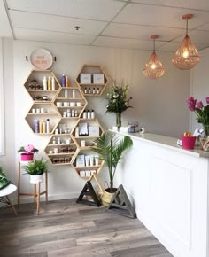 the front desk of a beauty salon with flowers and plants on display in vases