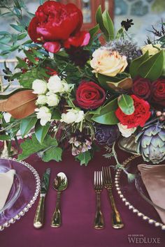 the table is set with silverware and flowers