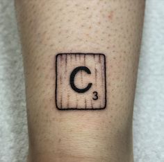 a person with a small tattoo on their leg that has the letter c in it