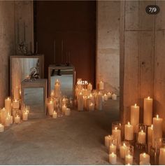 many lit candles are arranged on the floor