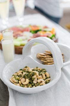 a table topped with plates and bowls filled with food next to glasses of milk, crackers and fruit