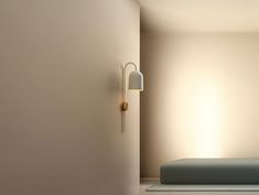 an empty room with a bed in the corner and a lamp on the wall next to it