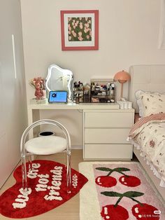 a bedroom with a desk, chair and rugs on the floor in front of it