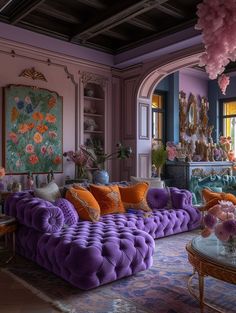 a living room filled with purple couches and lots of flowers on top of them