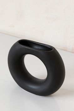 a black vase sitting on top of a white table