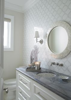 a bathroom with a sink, mirror and lights on the side of the vanity area