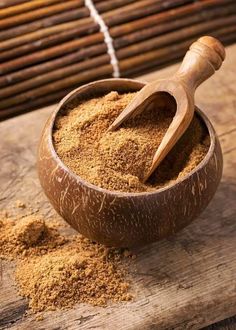 a wooden bowl filled with sand next to a bamboo mat and an old fashioned spatula