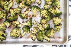 cooked broccoli florets on a baking sheet ready to go into the oven