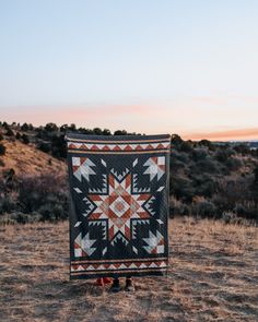 a quilt is sitting in the middle of a field