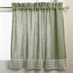 the curtain is hanging in front of a window with white trim and green fabric on it