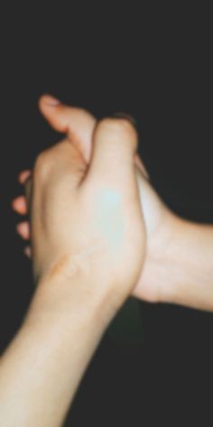 two hands reaching towards each other with one hand holding the other's arm in the air