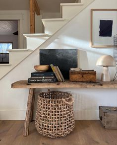 there is a basket under the table next to books and other things on the shelf