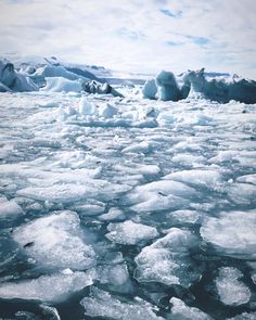 ice floes floating on the water with blue sky and clouds in the back ground