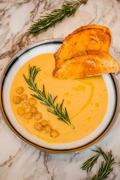 creamy tuscann chickpea soup in a bowl with bread on top