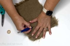 a woman is cutting fabric with scissors and shears on the table next to an apple watch